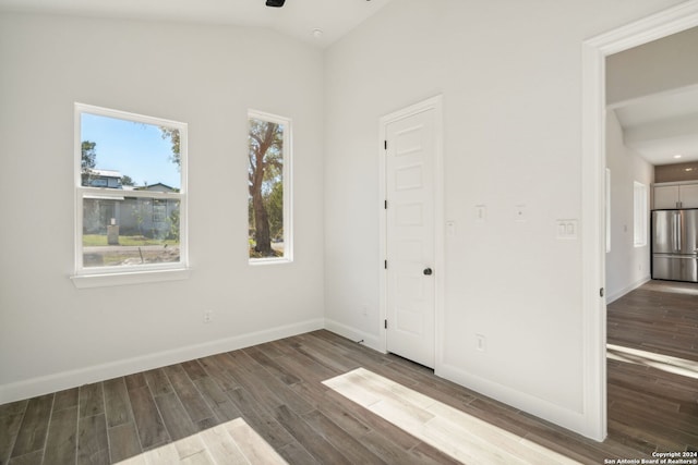 empty room featuring dark wood-type flooring and vaulted ceiling