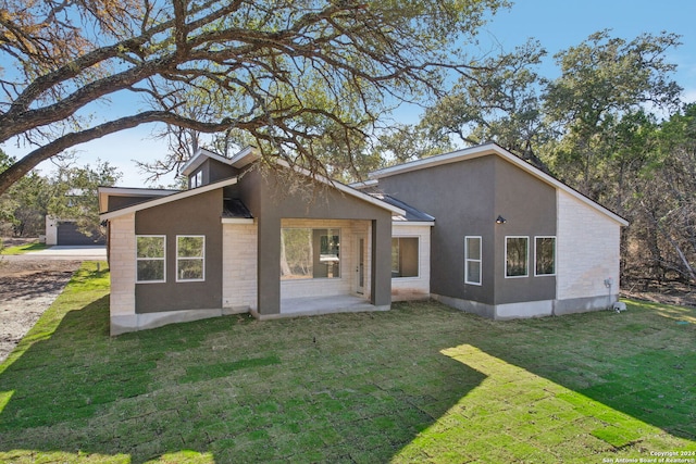 back of property featuring a yard and a patio area