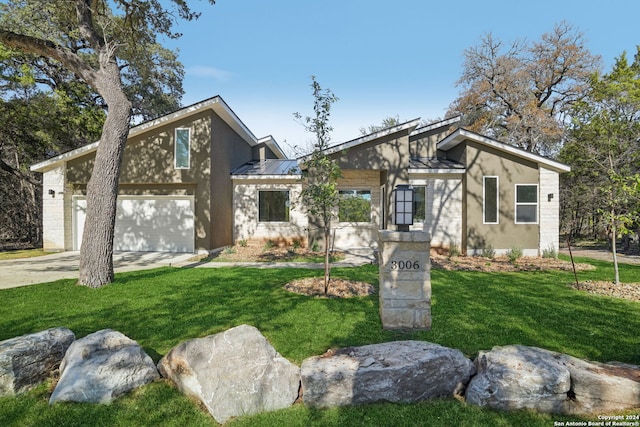 view of front of property with a garage and a front lawn