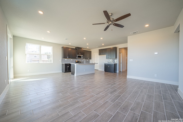 unfurnished living room featuring sink, ceiling fan, and hardwood / wood-style floors