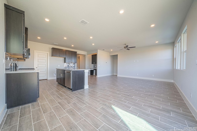 kitchen featuring ceiling fan, sink, light hardwood / wood-style floors, appliances with stainless steel finishes, and a center island with sink