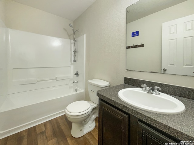 full bathroom with bathing tub / shower combination, hardwood / wood-style floors, vanity, and toilet