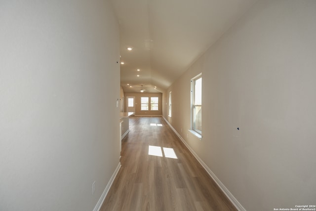 hallway featuring vaulted ceiling and light wood-type flooring