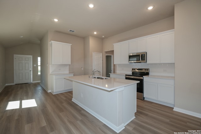 kitchen with sink, an island with sink, appliances with stainless steel finishes, light hardwood / wood-style floors, and white cabinetry