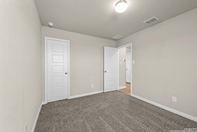 unfurnished bedroom featuring a closet, carpet, and a textured ceiling