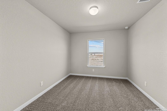 carpeted empty room with a textured ceiling