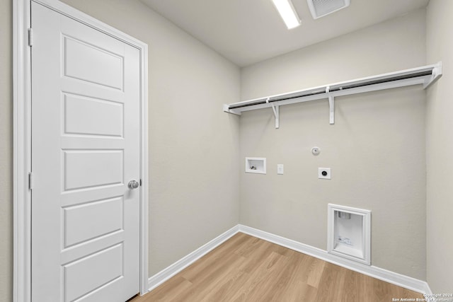 clothes washing area featuring hookup for an electric dryer, light hardwood / wood-style floors, gas dryer hookup, and hookup for a washing machine