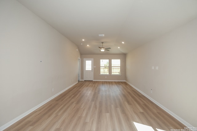 empty room featuring ceiling fan, lofted ceiling, and light wood-type flooring