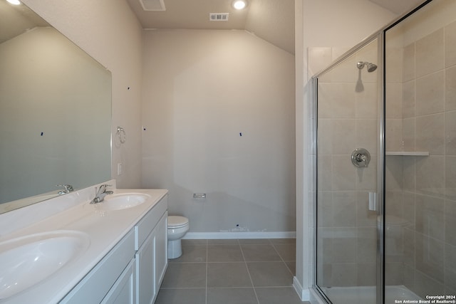 bathroom with tile patterned flooring, lofted ceiling, toilet, a shower with door, and vanity