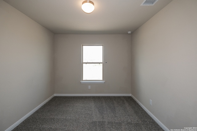 unfurnished room featuring dark colored carpet