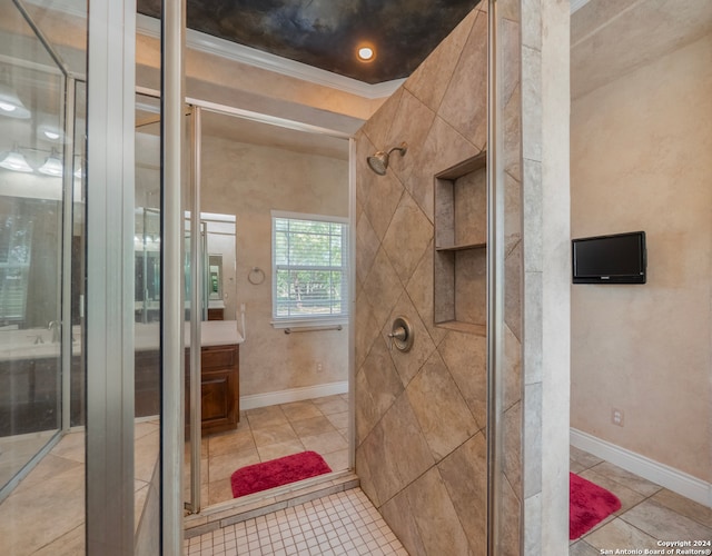 bathroom featuring ornamental molding, tile patterned flooring, walk in shower, and vanity