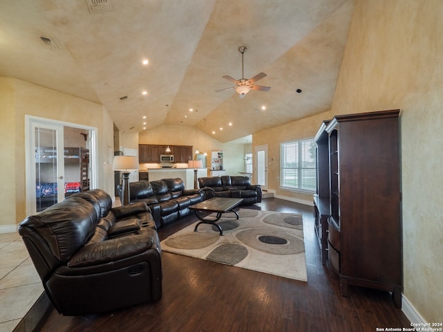 living room with ceiling fan, light hardwood / wood-style flooring, and vaulted ceiling