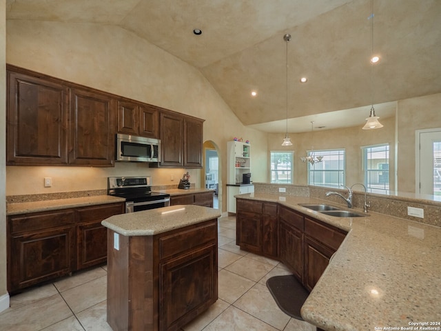 kitchen with pendant lighting, a kitchen island, sink, high vaulted ceiling, and appliances with stainless steel finishes