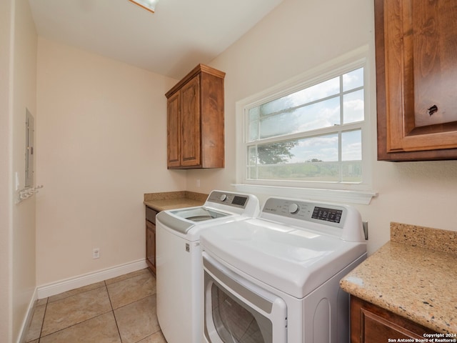 washroom with washer and clothes dryer, cabinets, light tile patterned floors, and electric panel