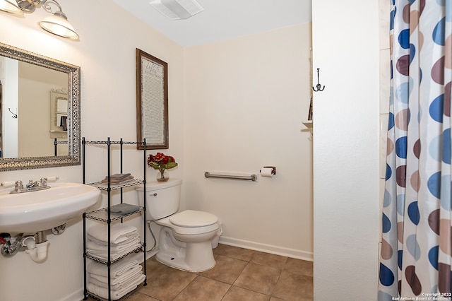 bathroom featuring tile patterned floors, toilet, sink, and a shower with curtain