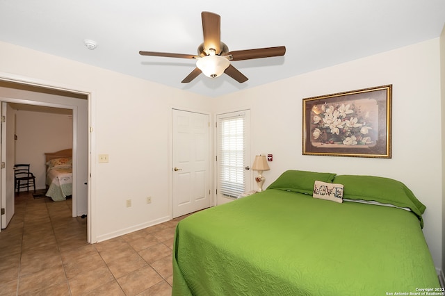 tiled bedroom featuring ceiling fan