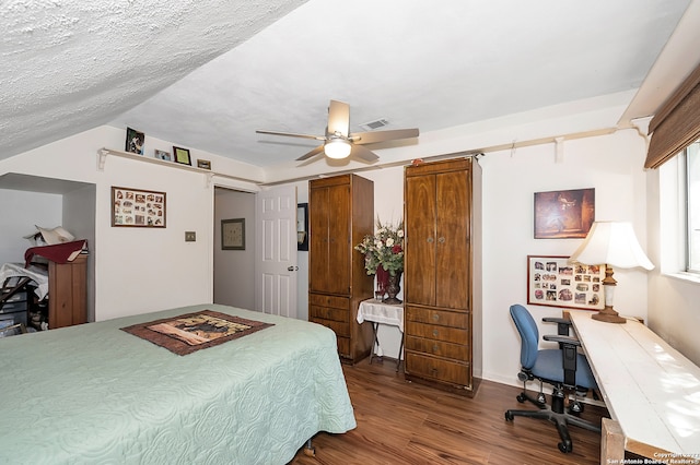 bedroom featuring ceiling fan, hardwood / wood-style flooring, lofted ceiling, and a textured ceiling