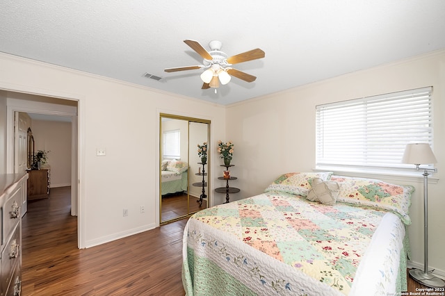 bedroom with multiple windows, ceiling fan, a closet, and dark hardwood / wood-style flooring