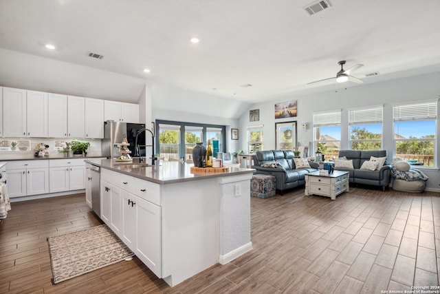 kitchen with lofted ceiling, a kitchen island with sink, white cabinets, sink, and dark hardwood / wood-style flooring