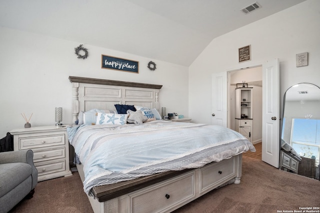 bedroom featuring lofted ceiling and dark colored carpet