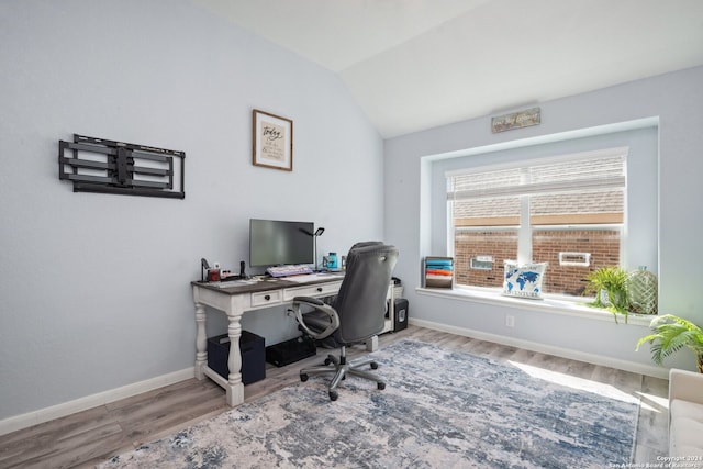 home office with lofted ceiling and hardwood / wood-style floors