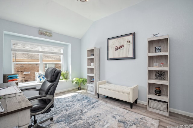 home office featuring vaulted ceiling and light hardwood / wood-style flooring