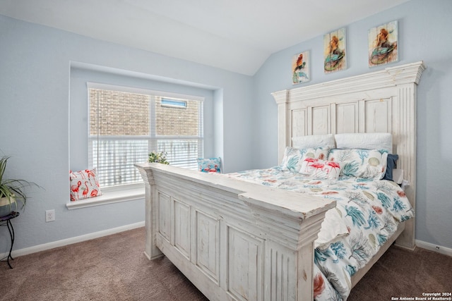 bedroom featuring lofted ceiling and dark carpet