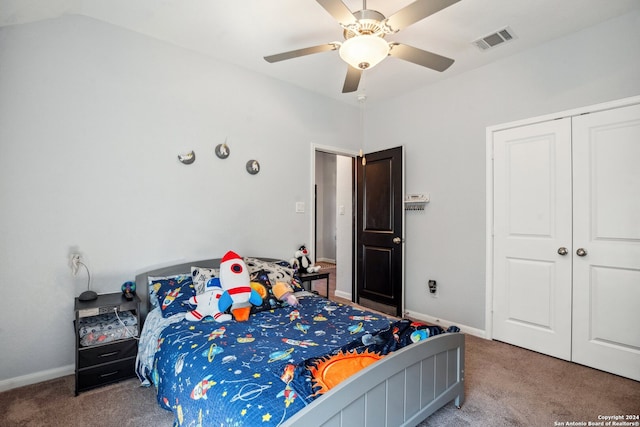 carpeted bedroom with ceiling fan, a closet, and vaulted ceiling