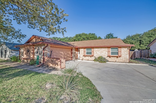 ranch-style home featuring a front yard and a garage