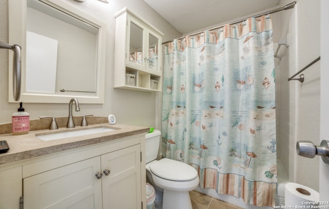 bathroom with curtained shower, tile patterned floors, vanity, and toilet