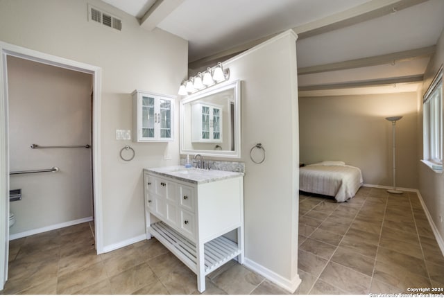 bathroom featuring beamed ceiling, toilet, and vanity