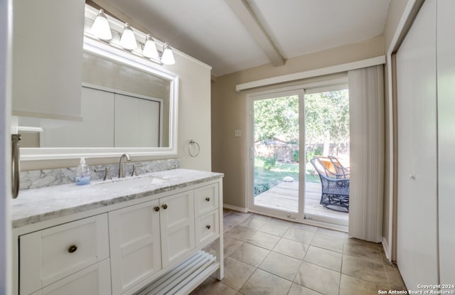 bathroom with tile patterned floors, beamed ceiling, and vanity