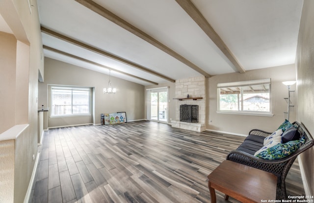 living room with an inviting chandelier, hardwood / wood-style flooring, a fireplace, and lofted ceiling with beams