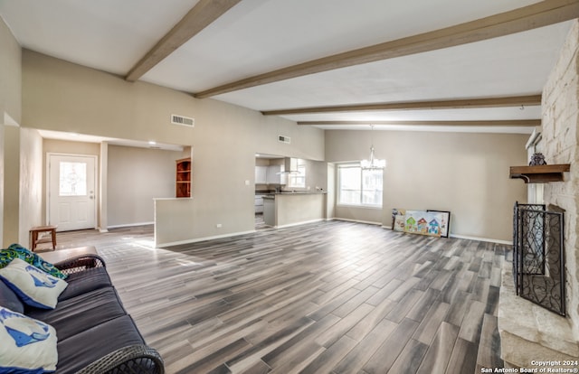 living room with a fireplace, lofted ceiling with beams, hardwood / wood-style floors, and a notable chandelier