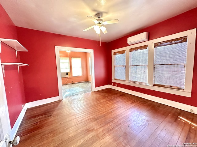 unfurnished dining area with an AC wall unit, ceiling fan, and wood-type flooring