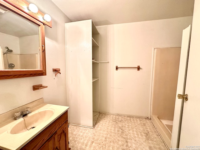 bathroom featuring walk in shower and vanity