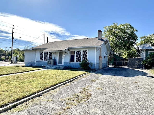 1244 Rigsby Ave, San Antonio, TX 78210 - ranch-style home featuring a front lawn, roof with shingles, a chimney, ac unit, and driveway