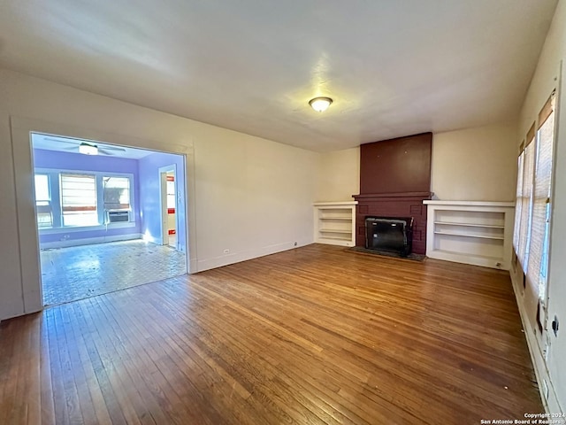1244 Rigsby Ave, San Antonio, TX 78210 - unfurnished living room with baseboards, a glass covered fireplace, ceiling fan, and hardwood / wood-style floors