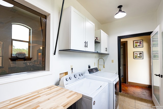 clothes washing area featuring separate washer and dryer, cabinets, light tile patterned floors, and sink