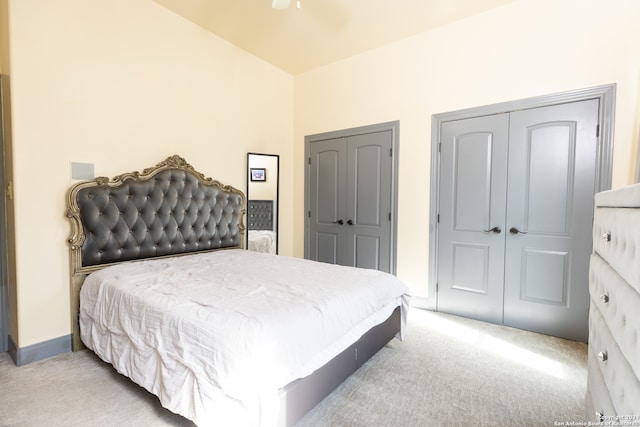 bedroom with light carpet and multiple closets