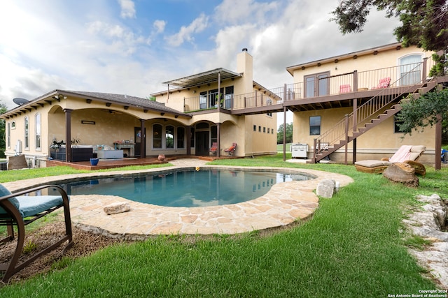 back of house with a patio, a yard, a balcony, and an outdoor living space