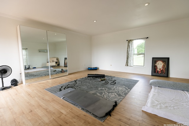 workout room featuring ornamental molding and light wood-type flooring