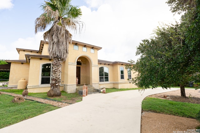 mediterranean / spanish-style house with a front lawn