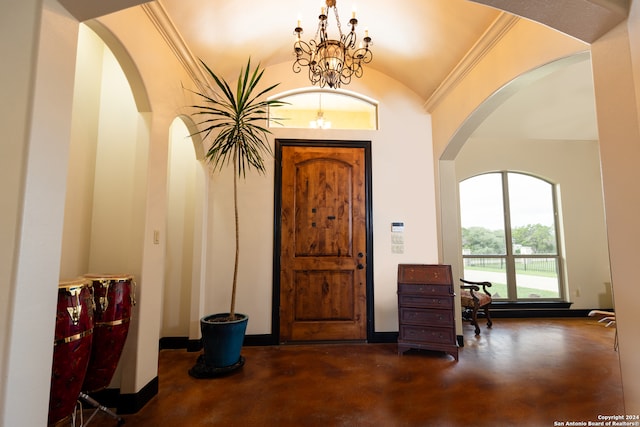 foyer entrance featuring ornamental molding, a notable chandelier, and vaulted ceiling