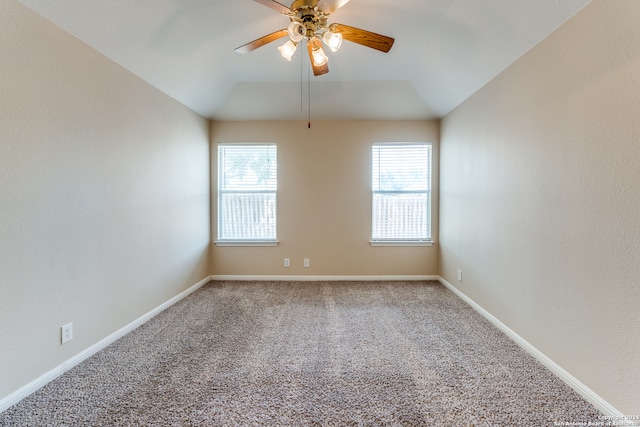 empty room with ceiling fan, carpet floors, and vaulted ceiling