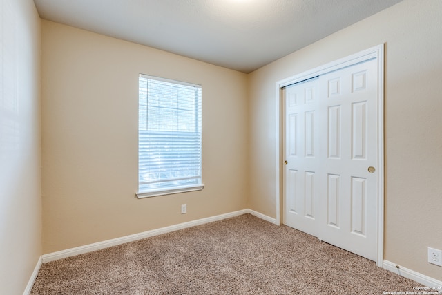 unfurnished bedroom with carpet floors and a closet