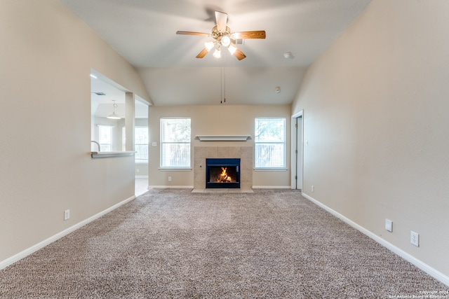 unfurnished living room featuring vaulted ceiling, carpet, and a tiled fireplace