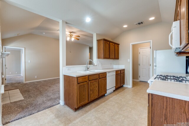 kitchen with lofted ceiling, ceiling fan, white appliances, sink, and light colored carpet