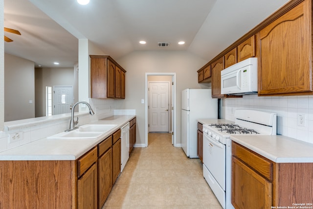 kitchen featuring white appliances, sink, light tile patterned flooring, vaulted ceiling, and backsplash