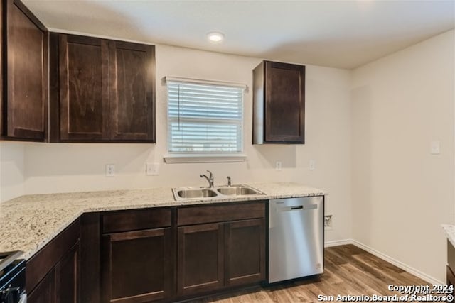 kitchen featuring light stone counters, hardwood / wood-style floors, stainless steel appliances, sink, and dark brown cabinets